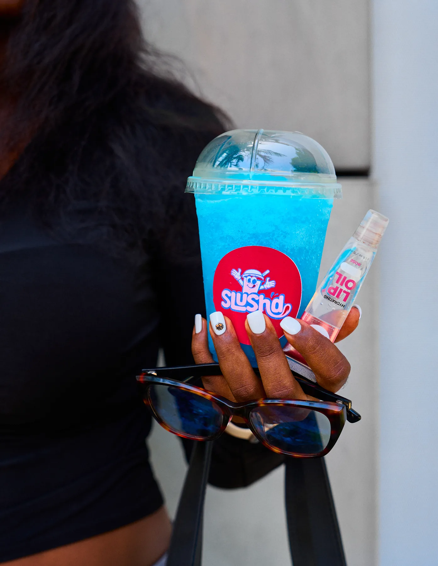 Photograph of a hand holding a blue Slush’d
